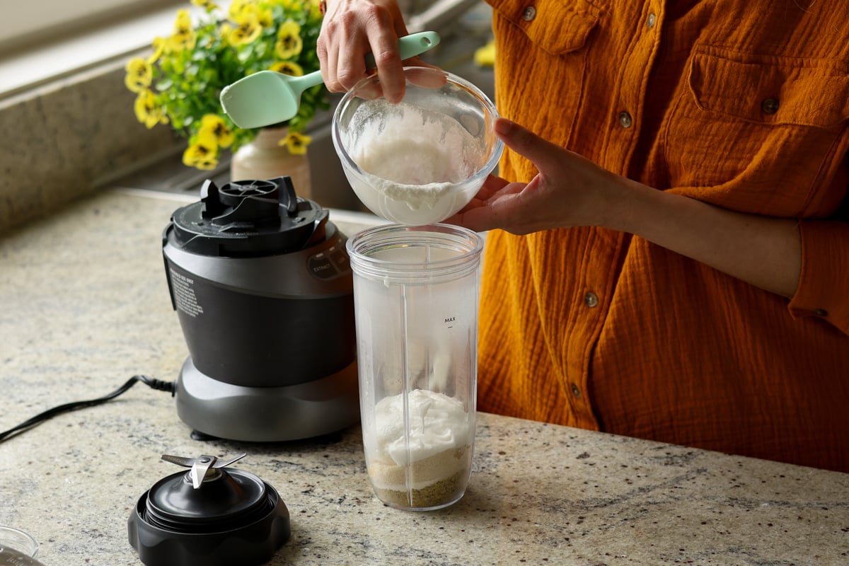 adding pistachio cram ingredients to the blender