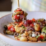 spooning a bite of sheet gnocchi and vegetables
