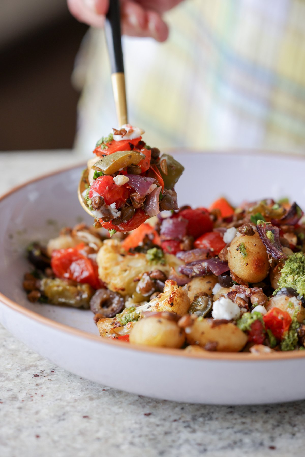 spooning a bite of sheet gnocchi and vegetables