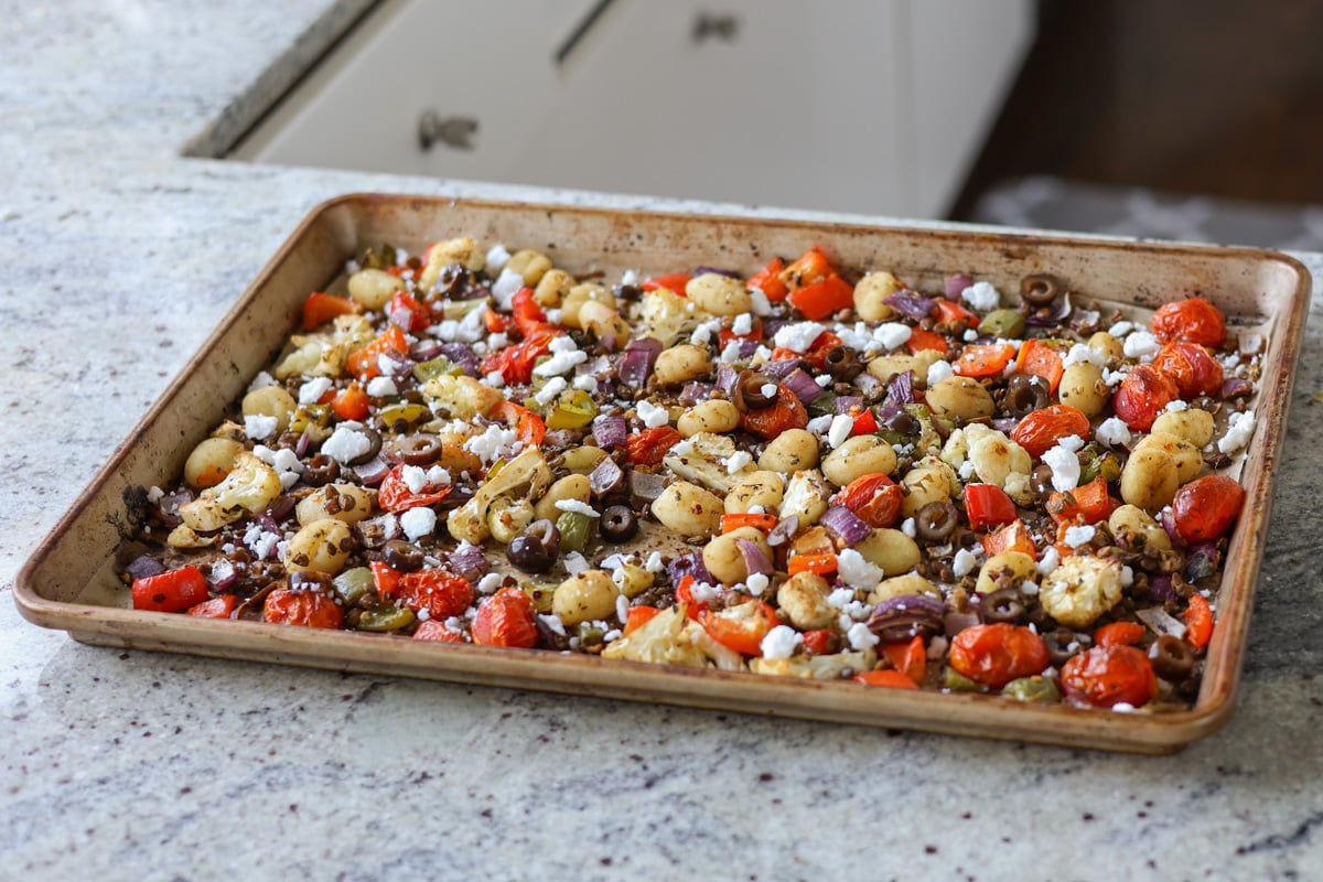 gnocchi and vegetables on the sheet pan after baking with toppings added