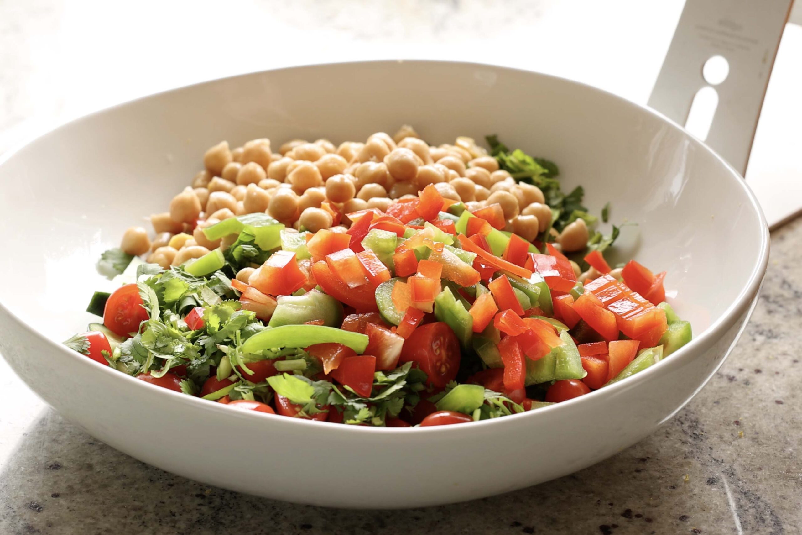 adding chickpeas to the bowl