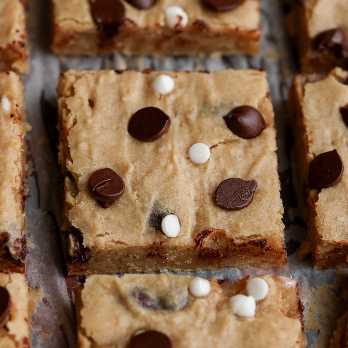 close-up of sliced white bean blondies on parchment paper
