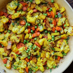 cooked cauliflower, peas, and carrots in a skillet
