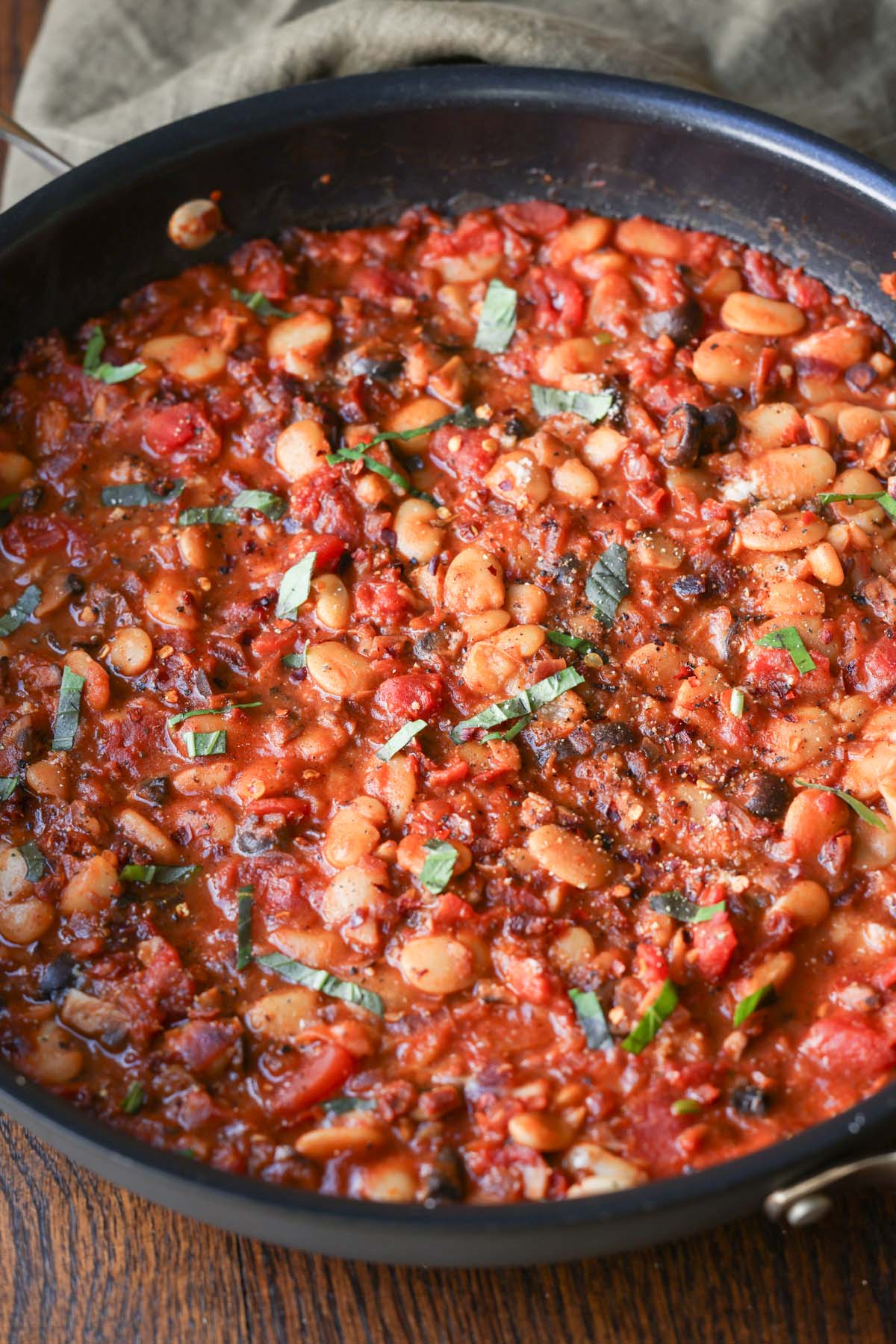 close-up of puttanesca beans in the pan