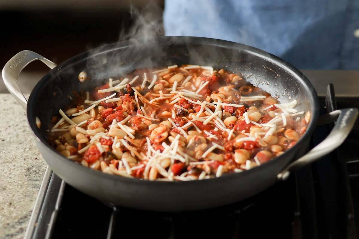 adding vegan mozzarella to the pan