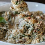 fork taking a bite of spinach artichoke gnocchi
