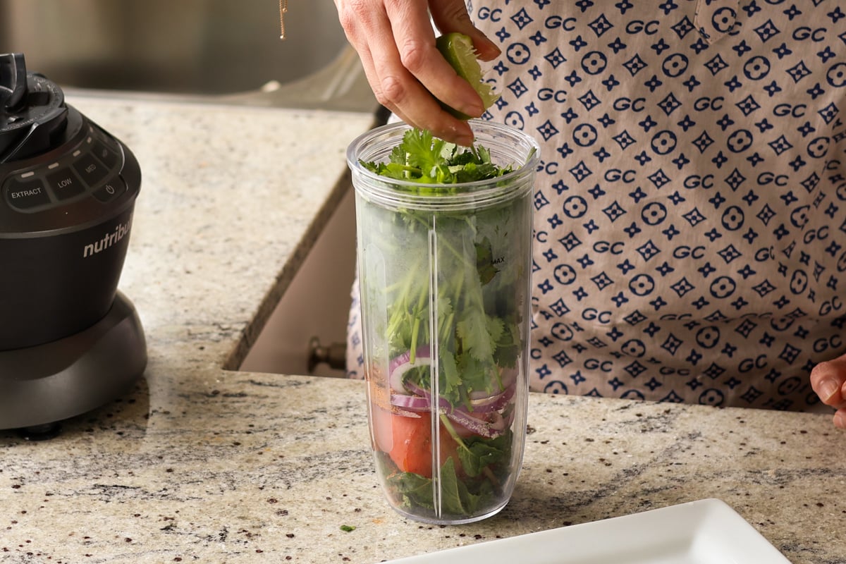 adding mint chutney ingredients to the blender