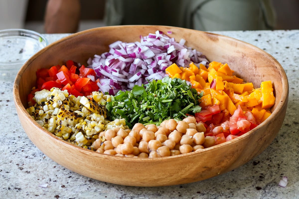 mango chickpea salad ingredients in the bowl before adding dressing