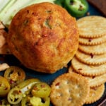 jalapeno popper cheese ball on a serving tray with crackers and veggies