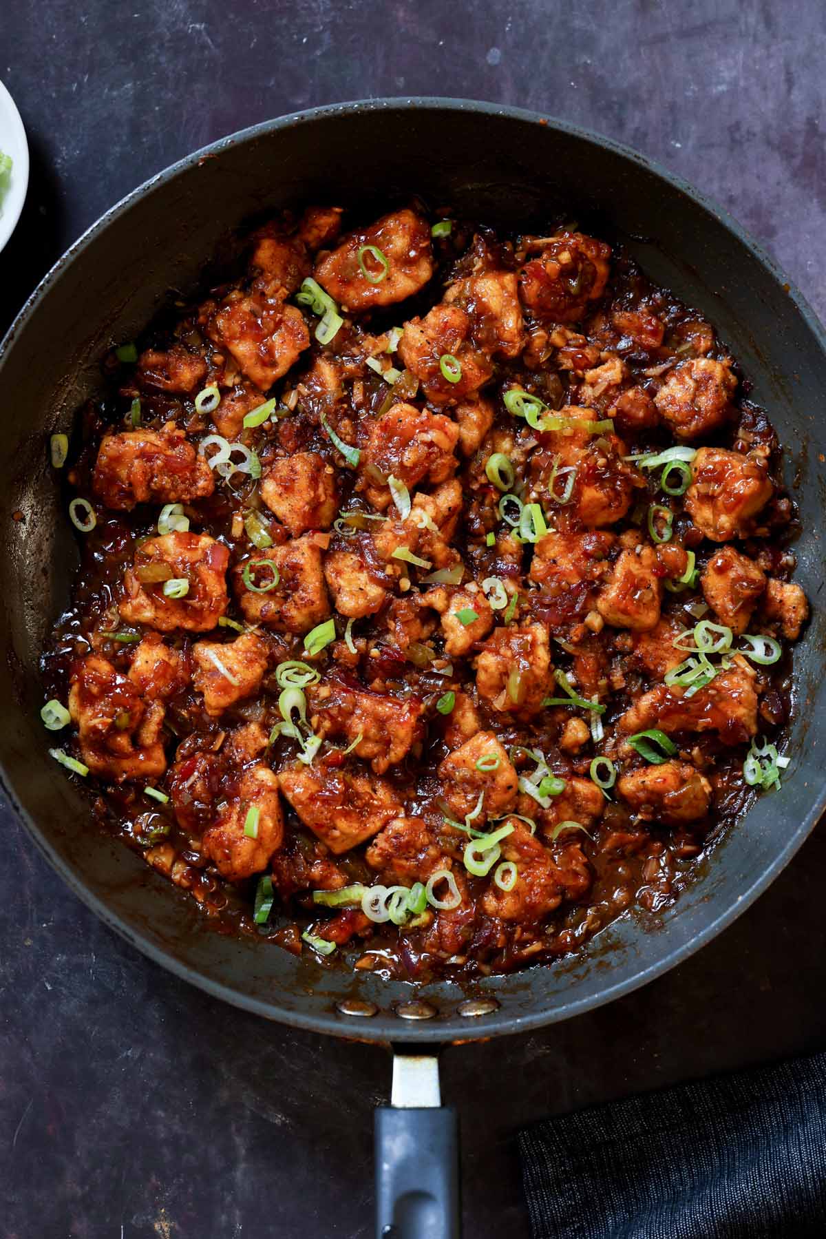 Indo-Chinese garlic pepper tofu in the pan with green onion