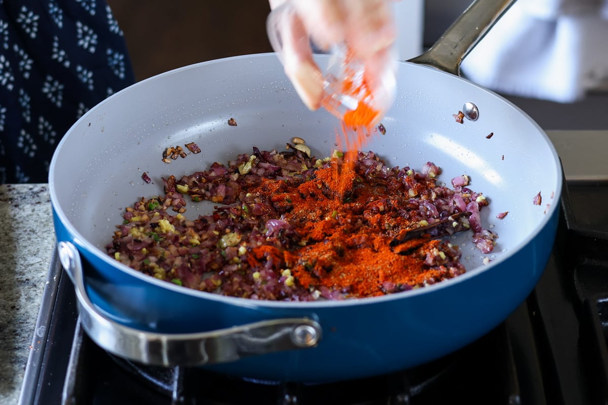 adding kashmiri chili powder to the pan