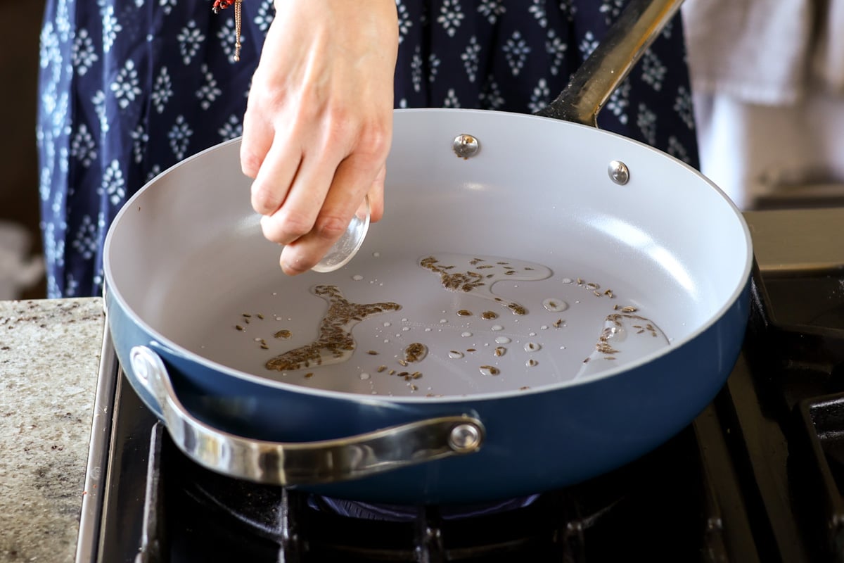 adding whole spices to the pan