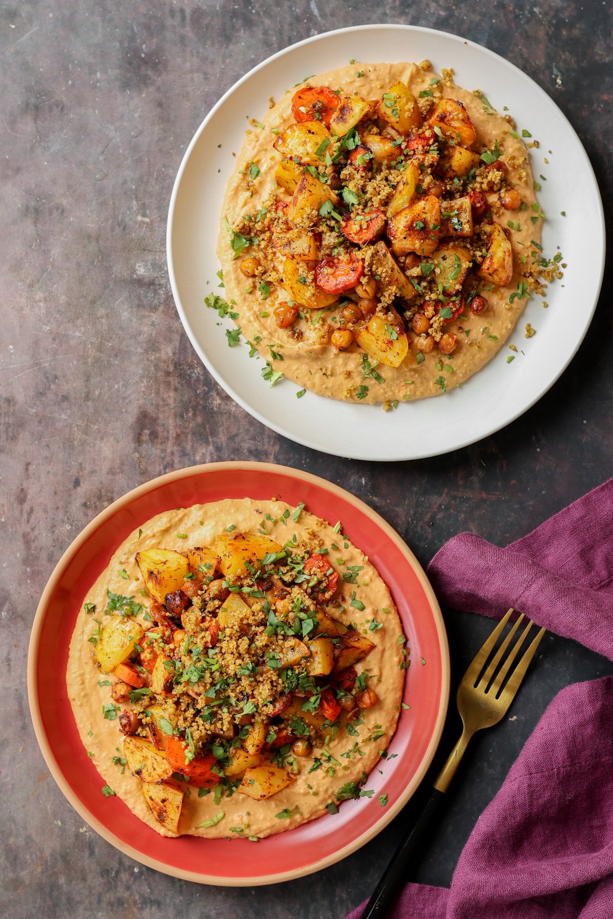 plates of harissa bean puree topped with roasted vegetables and baharat walnuts