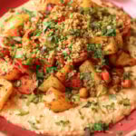 close-up of harissa bean puree topped with roasted vegetables and baharat walnuts