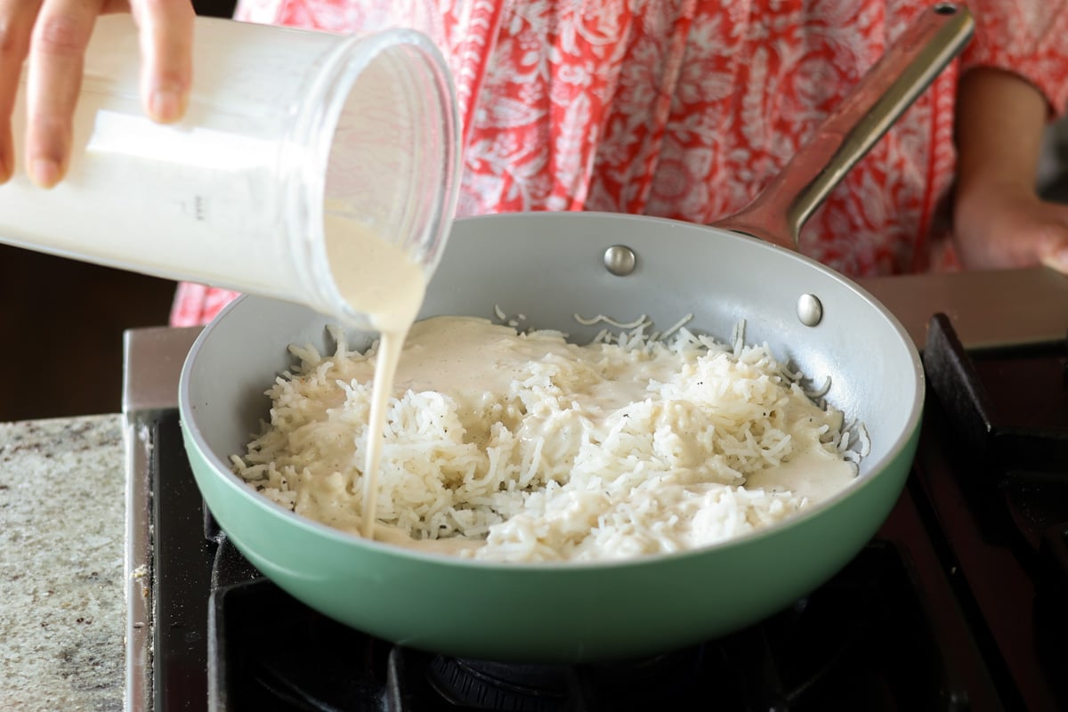 adding cashew cream to the cooked rice