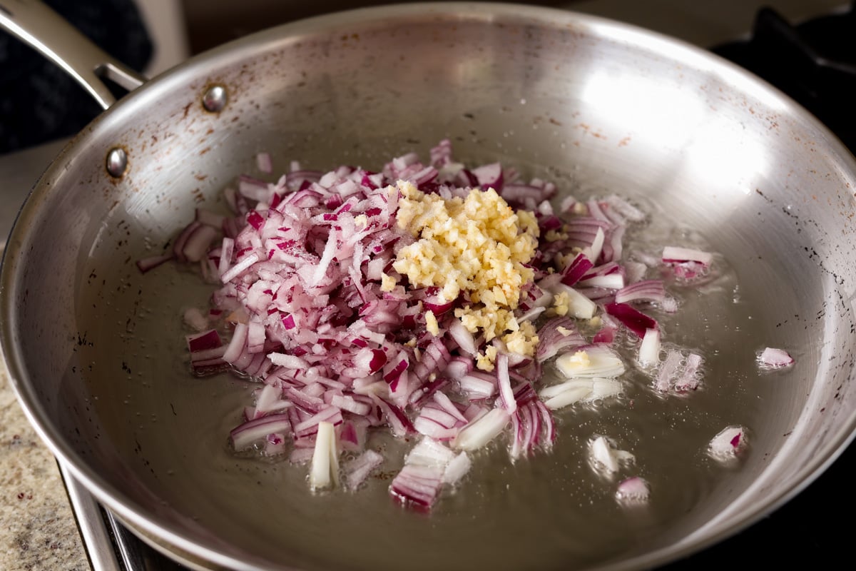 adding onion and garlic to the pan