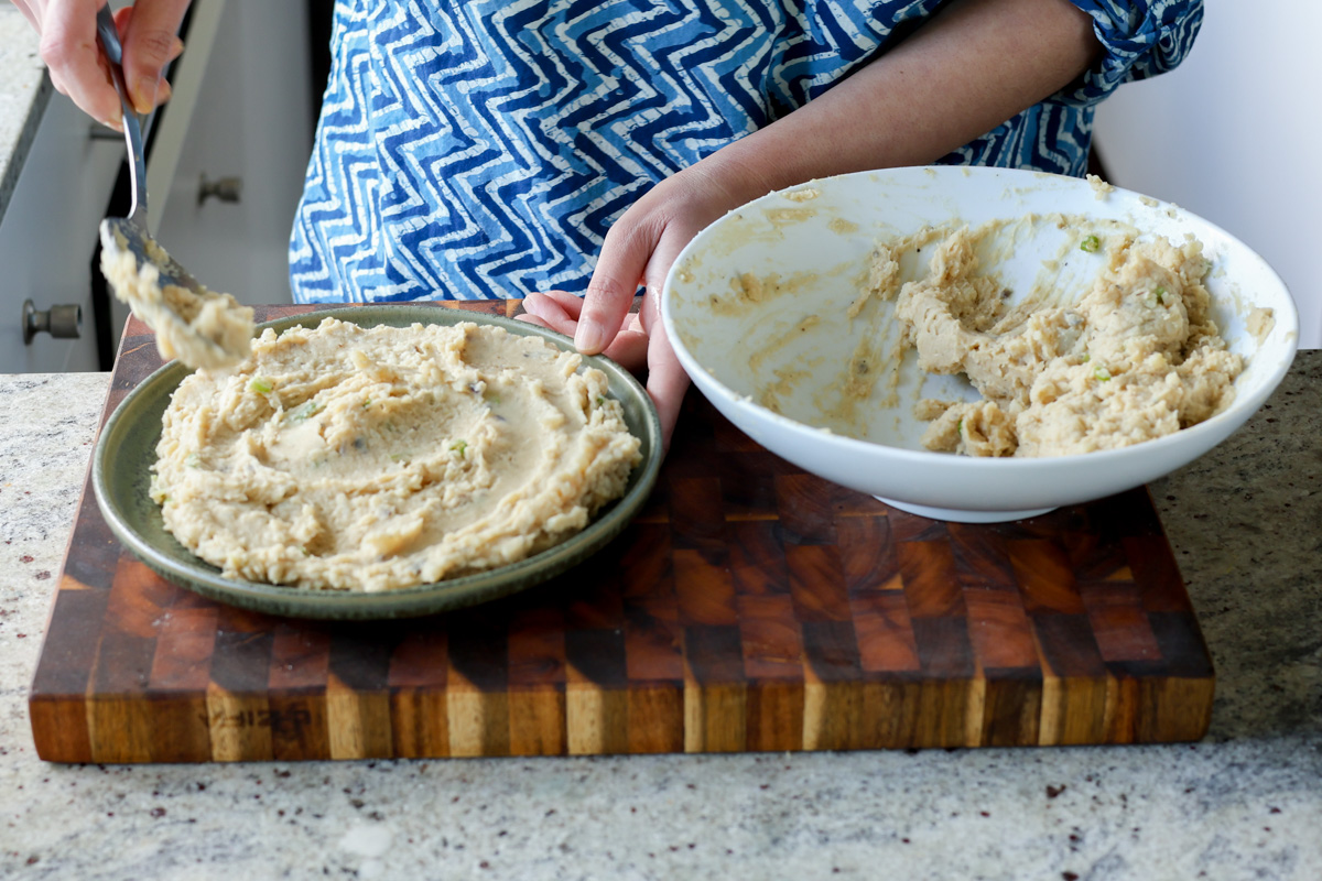 adding the mashed potatoes to the serving bowl