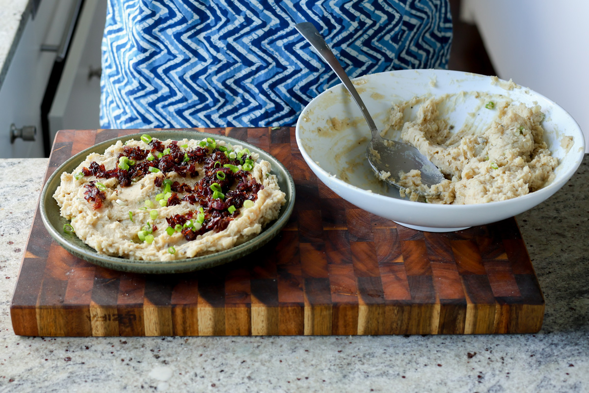 topping the mashed potatoes with caramelized onions