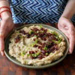 placing a plate of caramelized onion mashed potatoes on the table