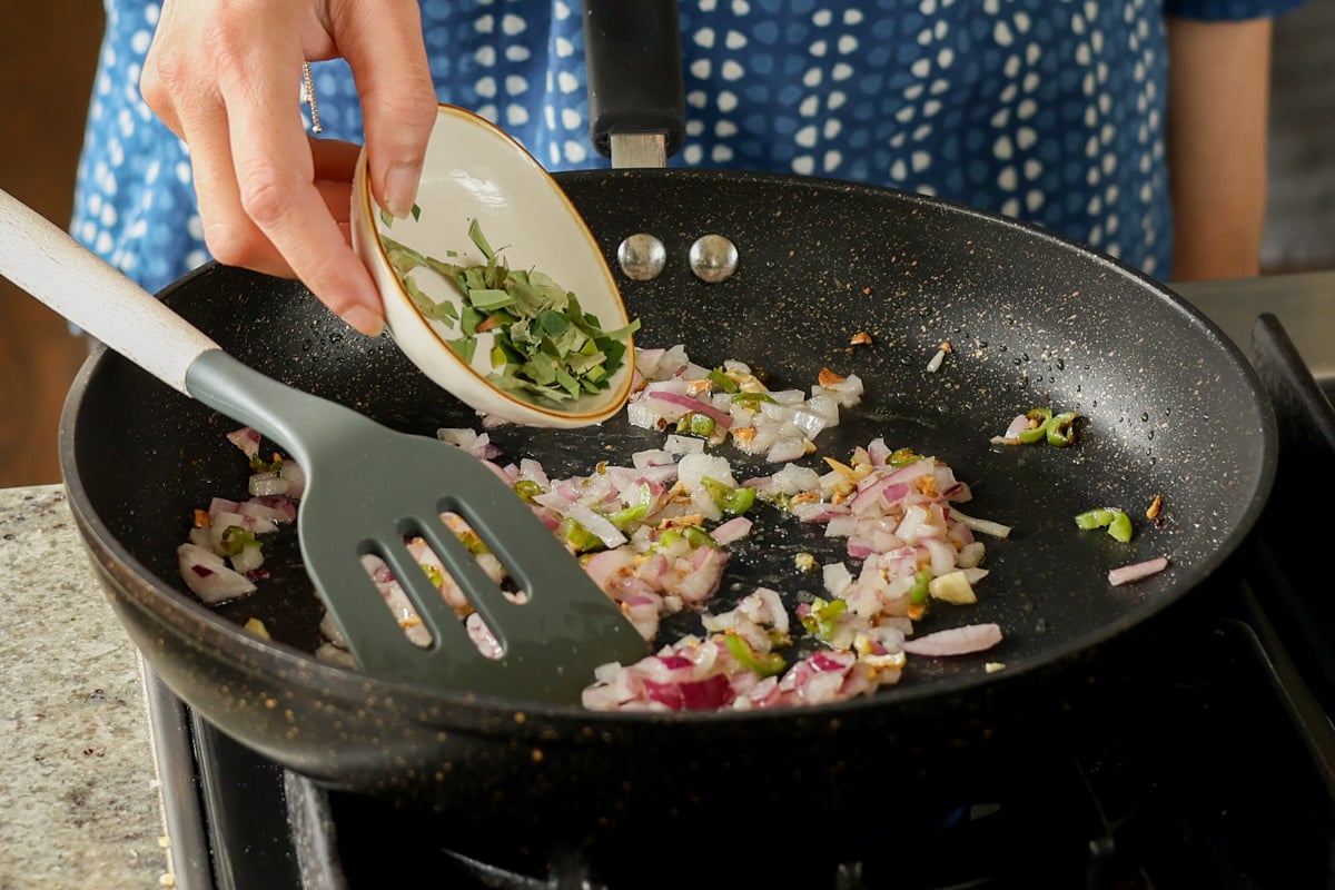 adding green chili to the pan