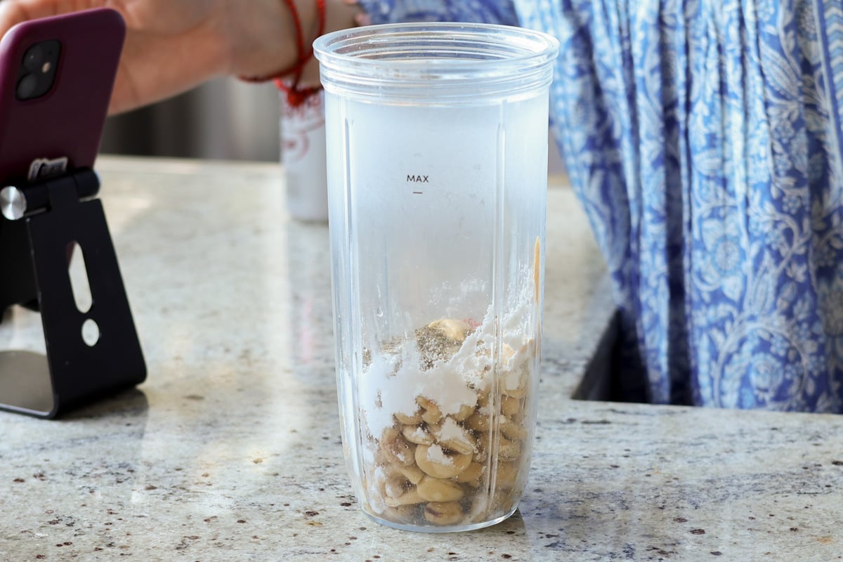 adding holiday cheese log ingredients to the blender