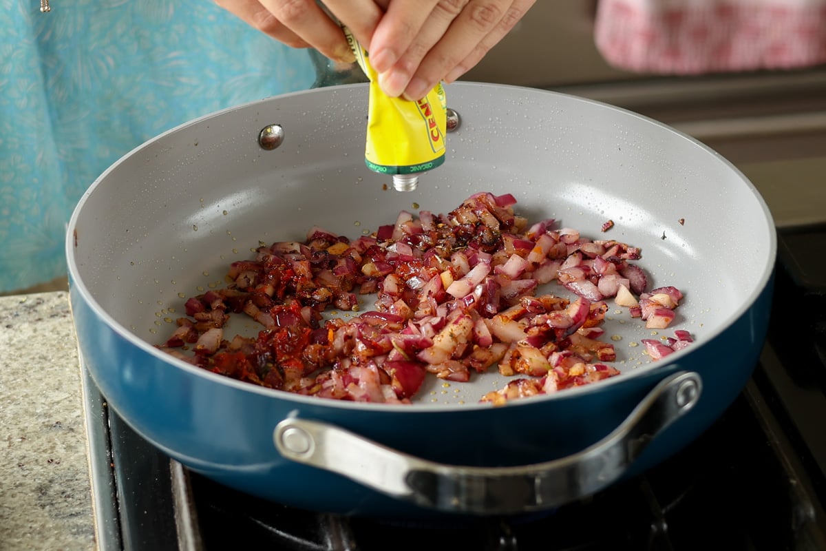 adding tomato paste to the aromatics