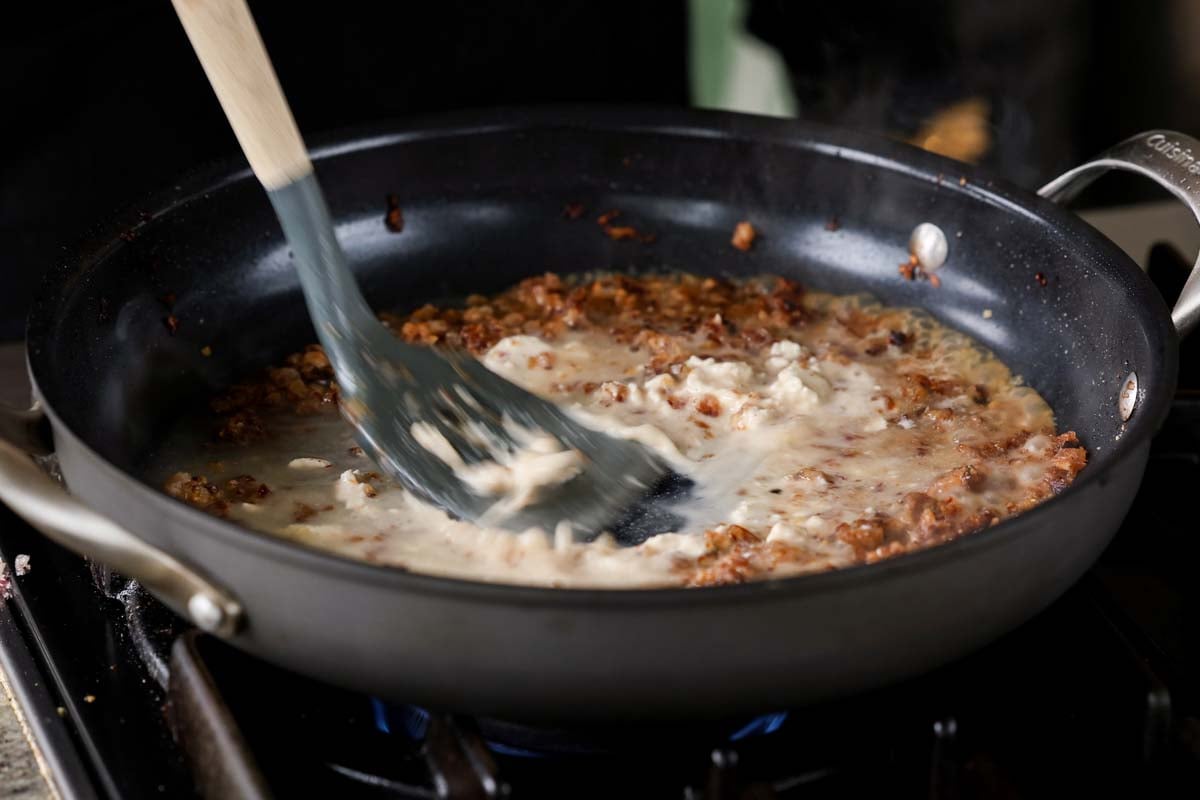 mixing the vegan cream cheese into the stock