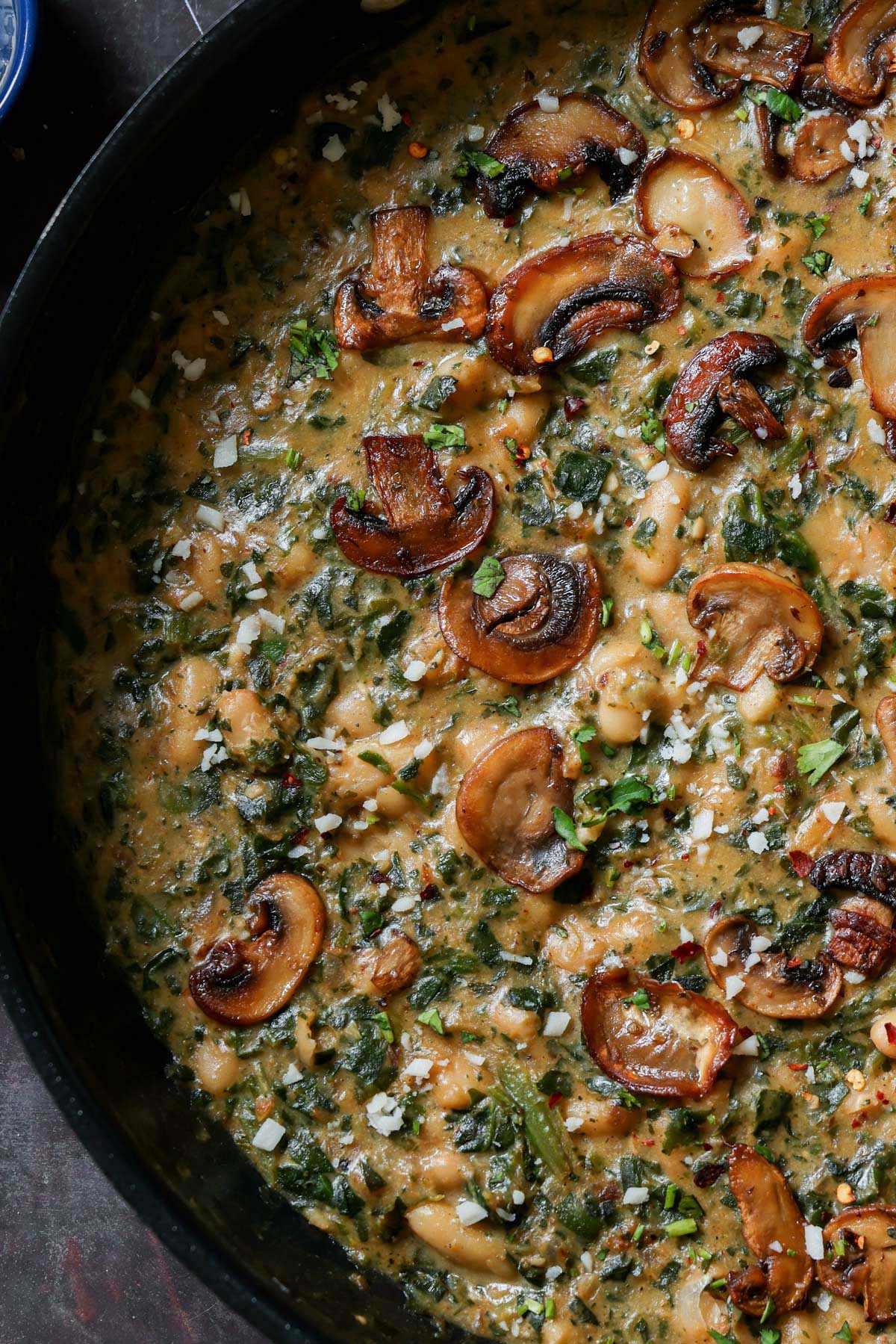 close-up of spinach mushroom beans in the pan with garnish