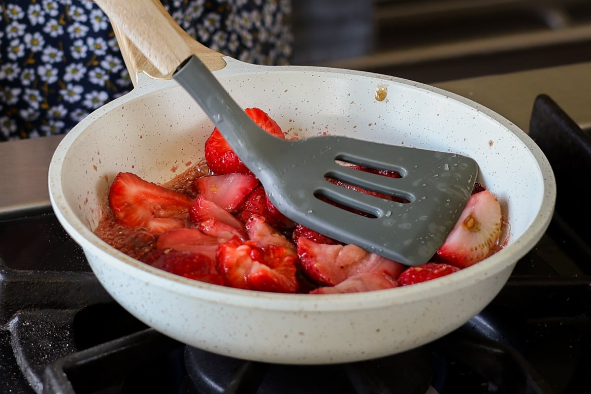 mashing the strawberries in the pan