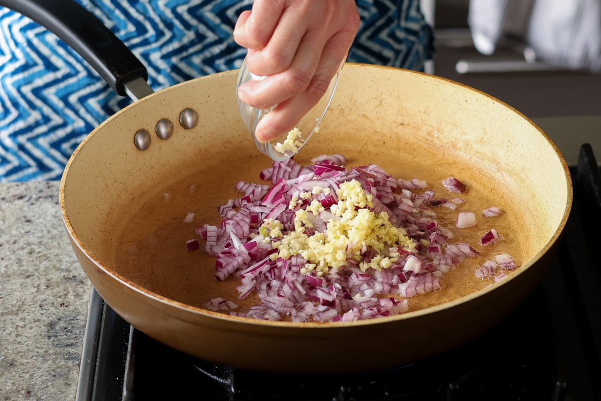 adding onion and garlic to the pan