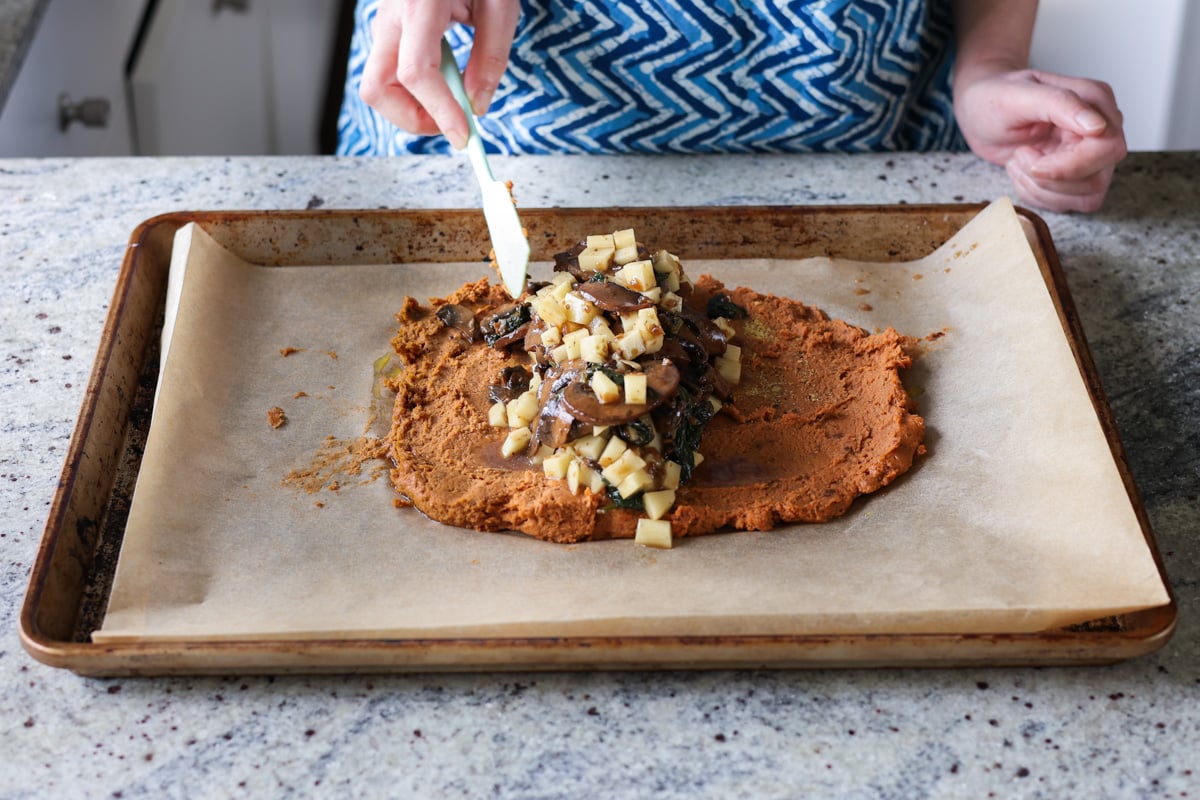 adding the stuffing to the sun dried tomato roast