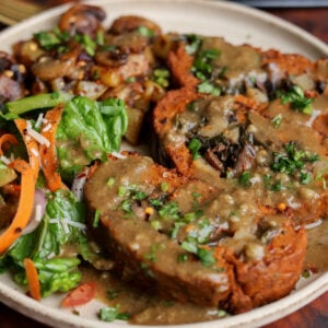 close-up of sun dried tomato roast on a plate with salad and mushrooms