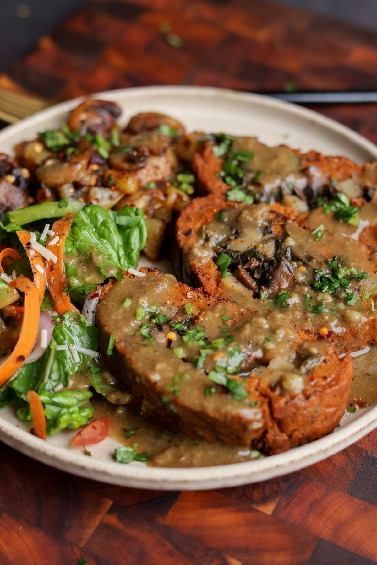 close-up of sun dried tomato roast on a plate with salad and mushrooms