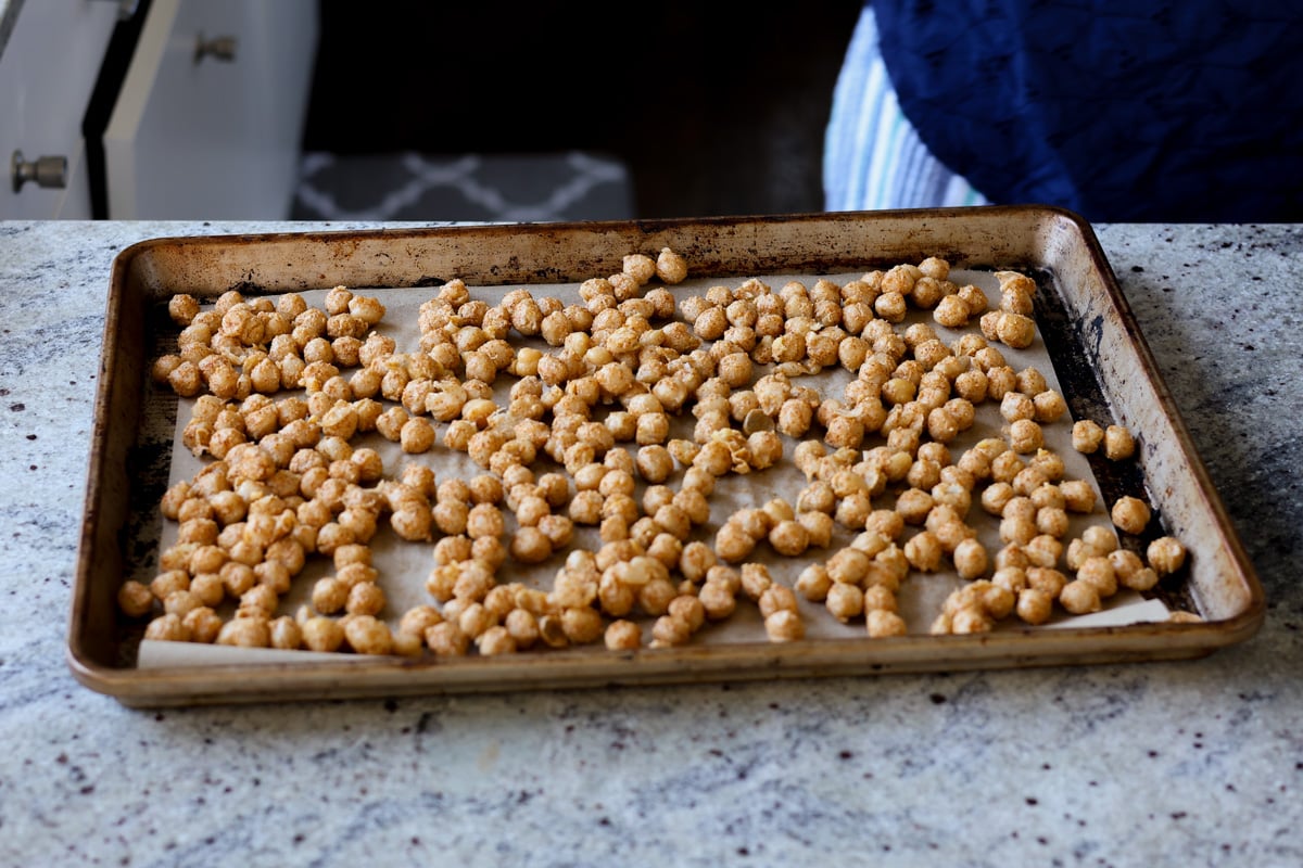 chickpeas spread out on the baking sheet before baking
