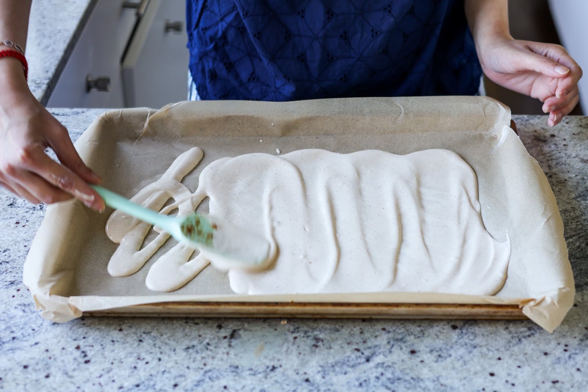 spreading blended tofu mixture onto the baking sheet