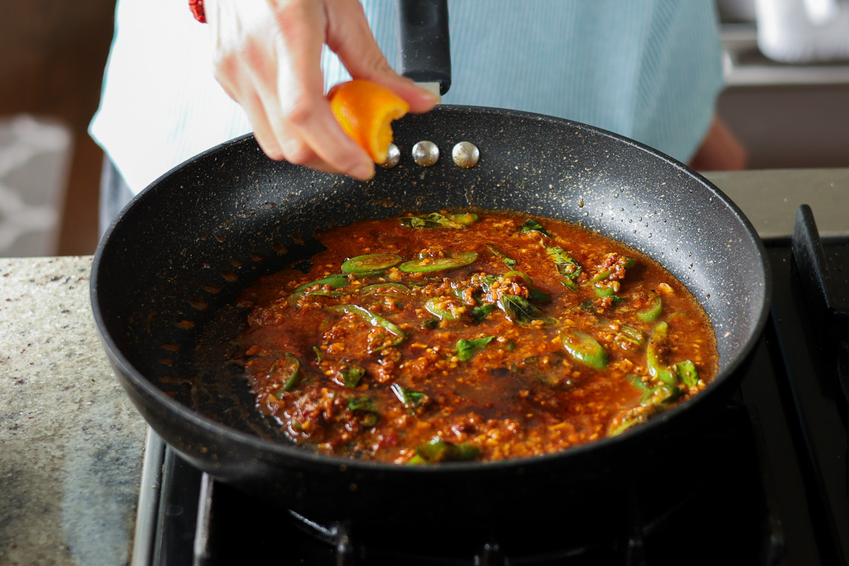 squeezing orange juice into the pan