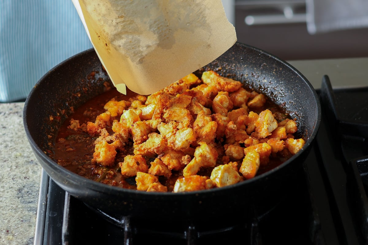 adding tofu to the sauce