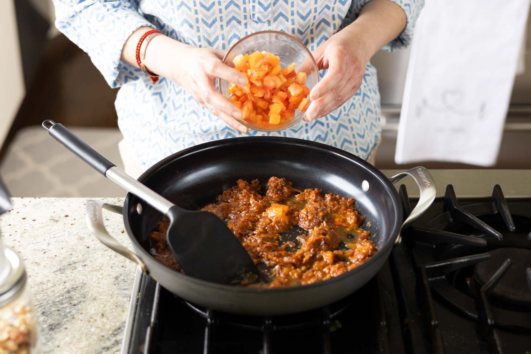 adding tomato to the pan