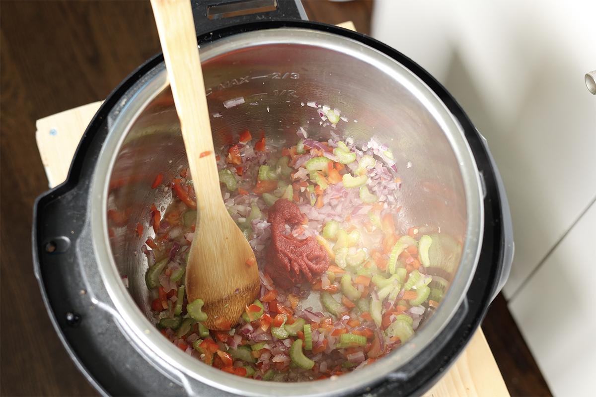 adding tomato paste to the pot