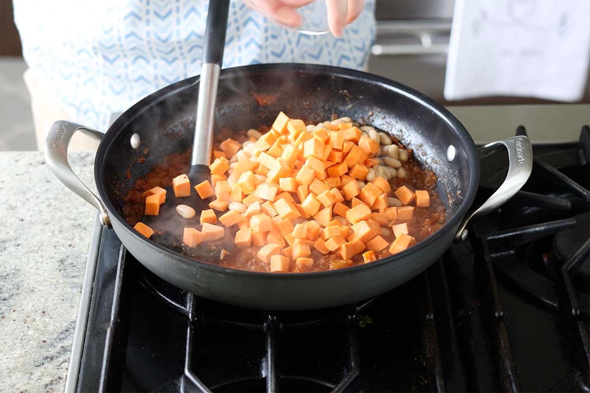 adding sweet potatoes to the pan