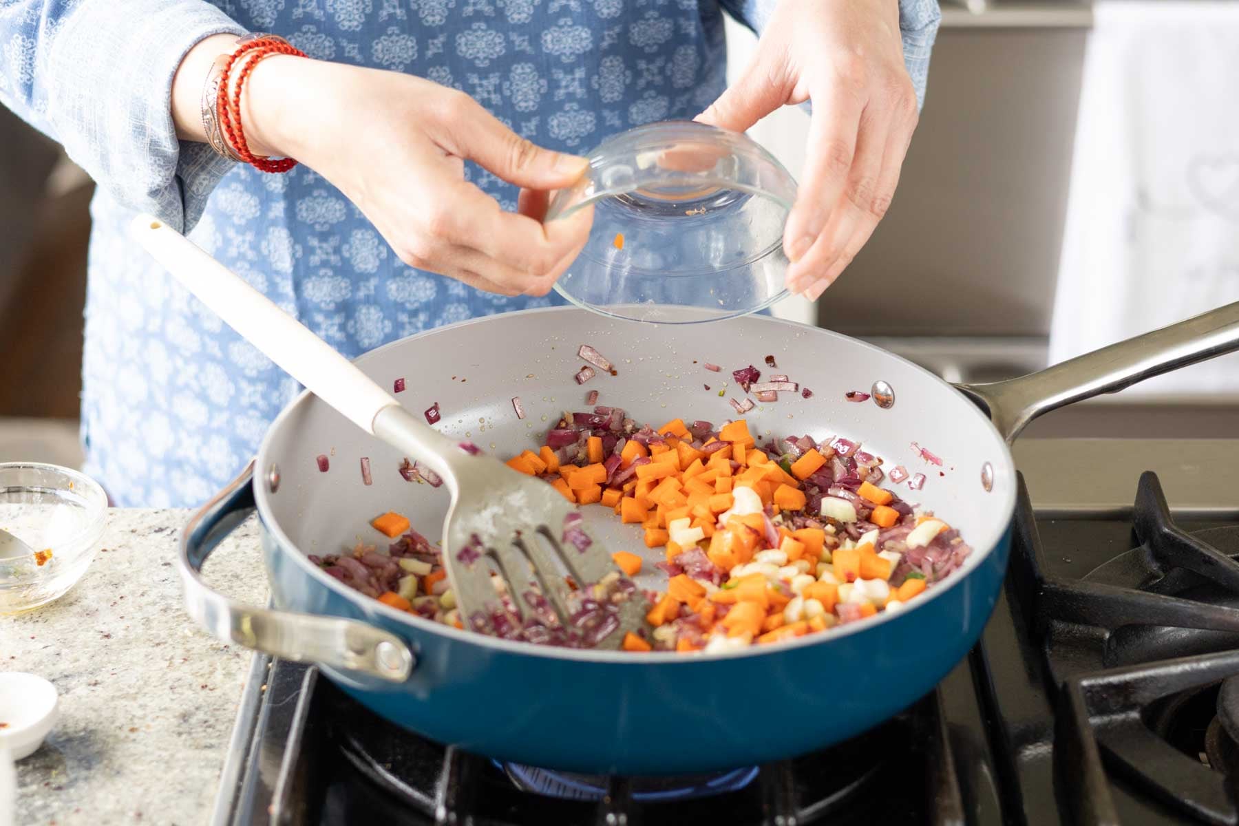 adding veggies to the pan