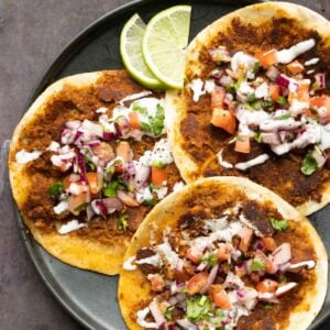 chickpea mushroom smash burger tacos on a plate with lime and toppings