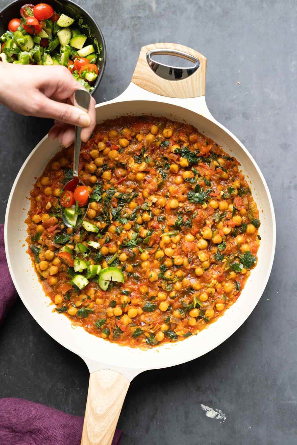 adding the salsa to the peri-peri chickpeas in the pan after cooking