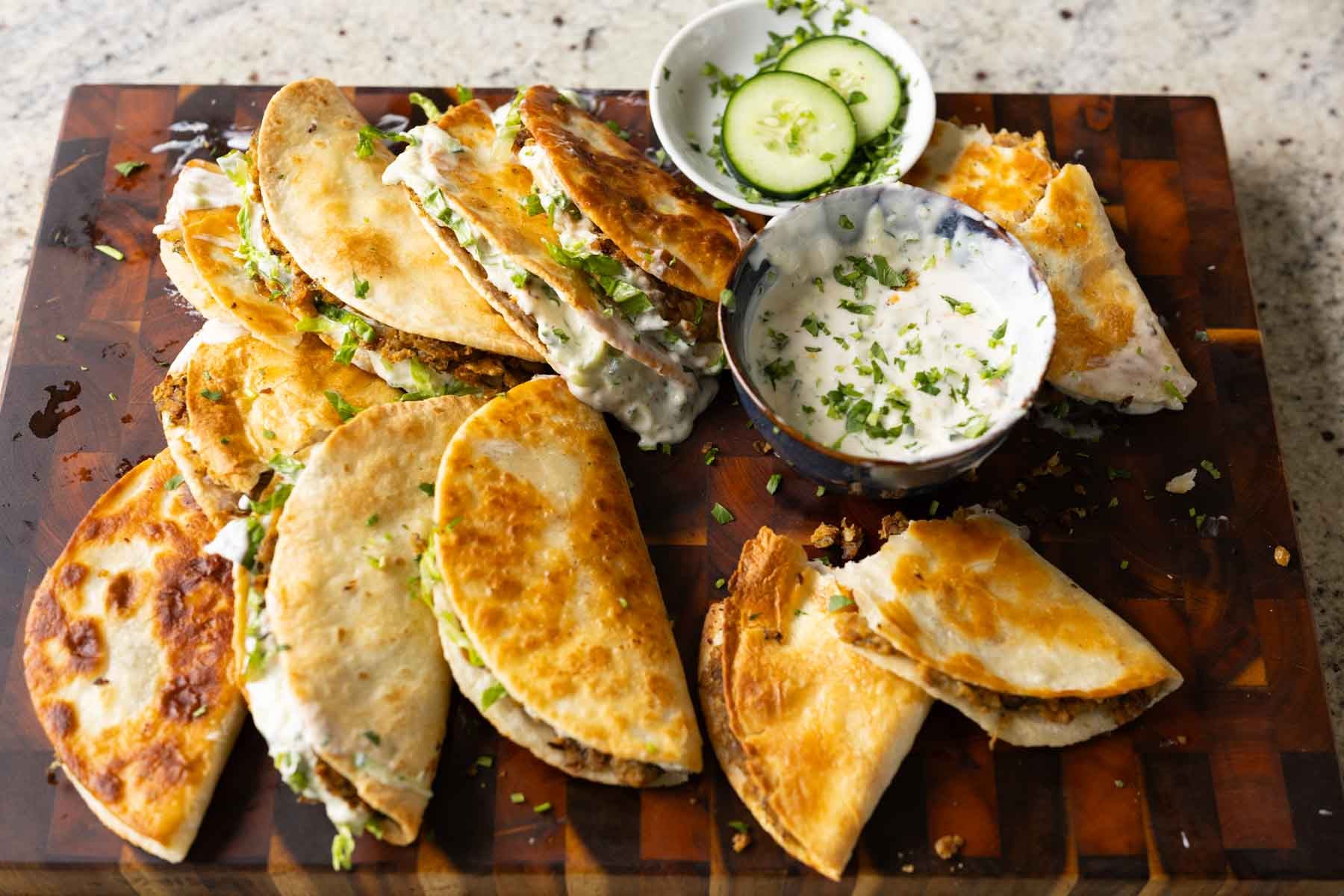stuffed paratha tacos on a serving platter with extra raita