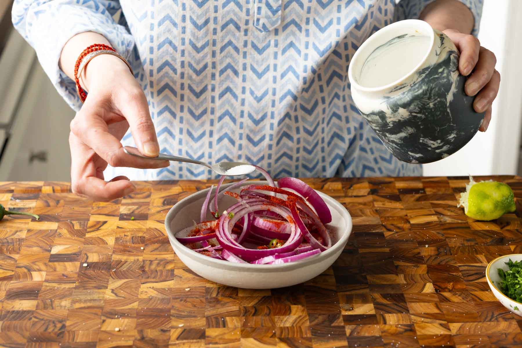 adding onion salad ingredients to a bowl