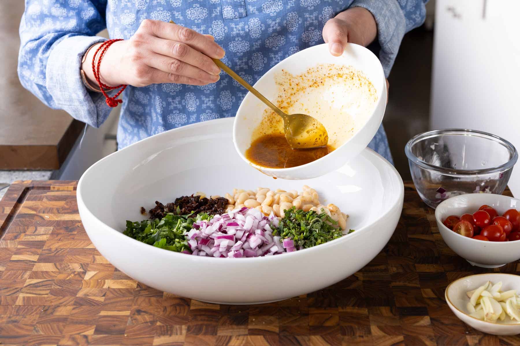 adding dressing to the white beans and veggies