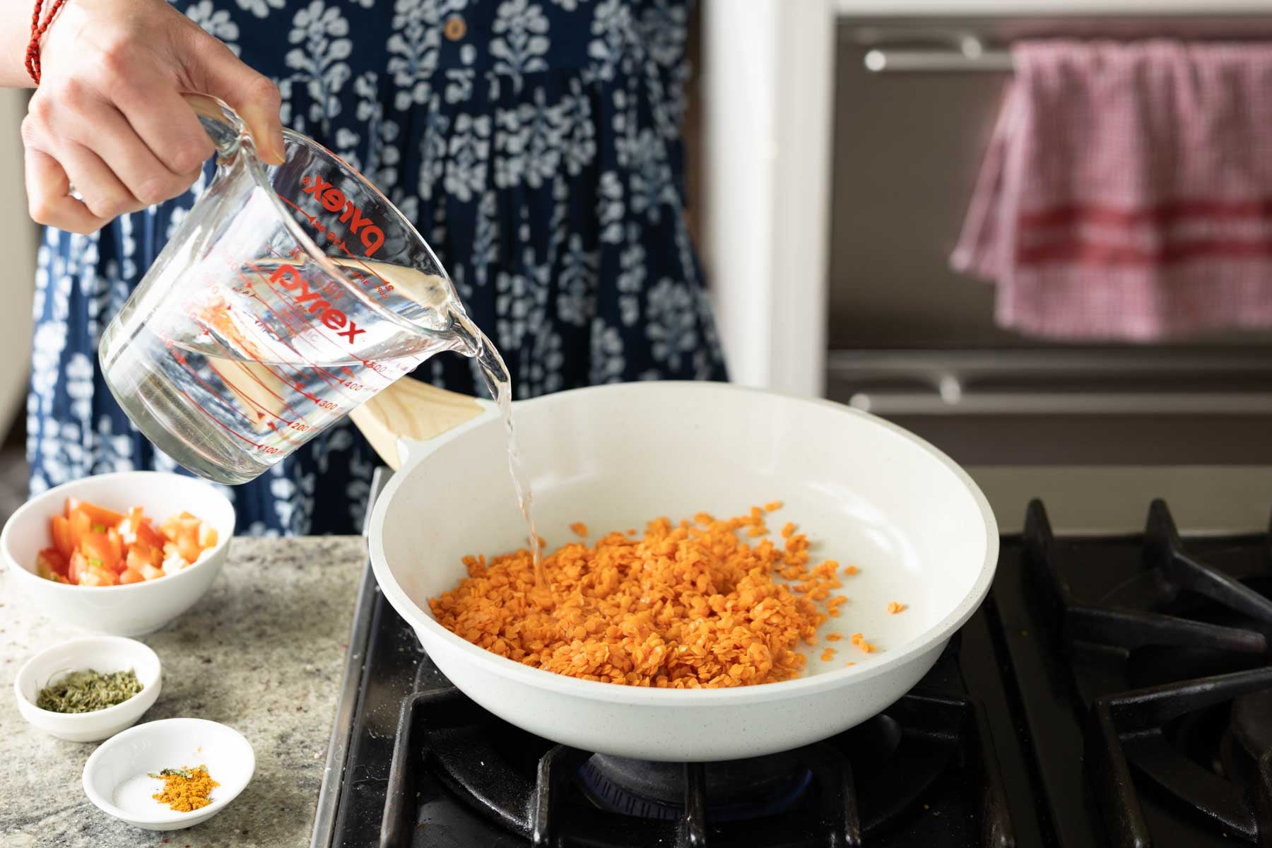 adding lentils and water to the pan