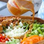 pouring the dressing onto the gochujang salad