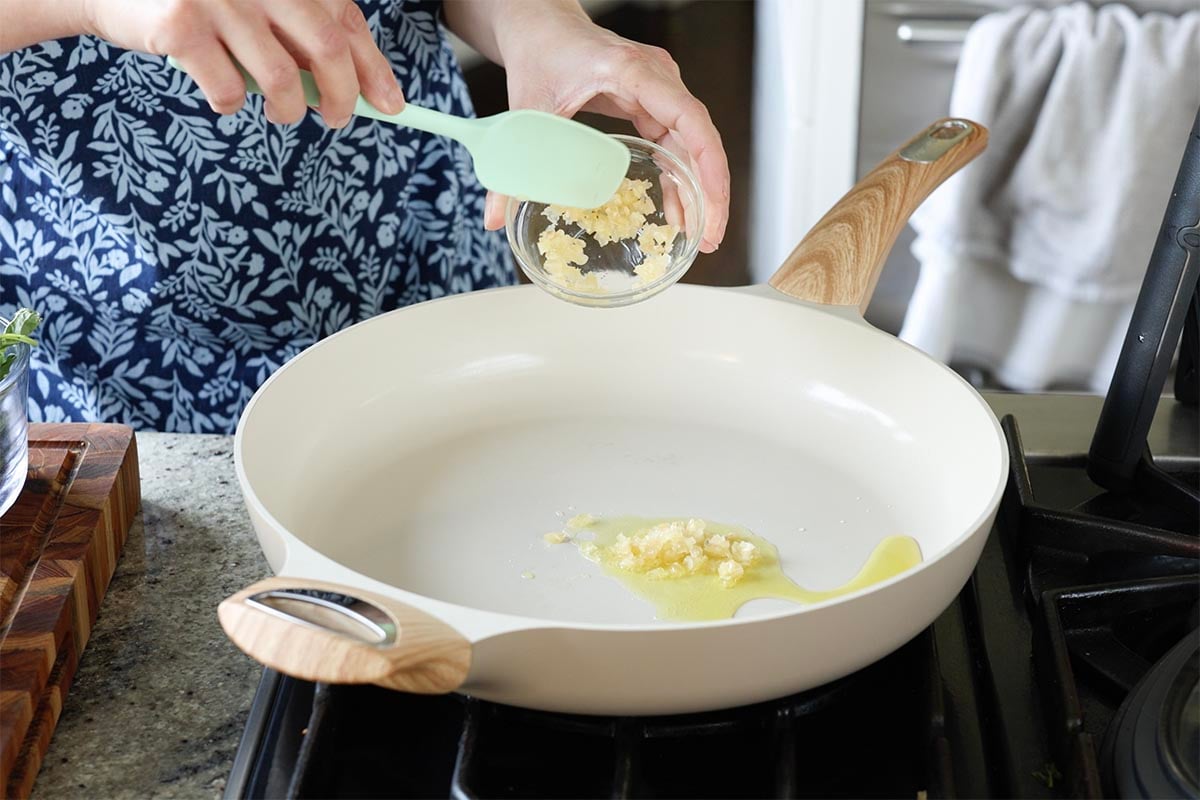 adding the garlic to the pan
