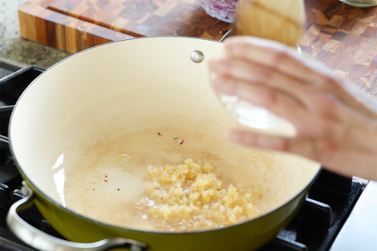 adding garlic to the pan